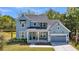 Charming light blue two-story home with a welcoming front porch and well-manicured lawn at 1184 Reserve Ln, Awendaw, SC 29429