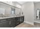 Bathroom featuring double sinks, granite countertops, dark cabinets, and an oversized mirror at 139 Calm Water Way, Summerville, SC 29486