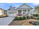 Charming one-story home featuring an inviting front porch, an orange front door, and a two-car garage at 139 Calm Water Way, Summerville, SC 29486