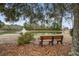 A wooden bench provides a place to sit and enjoy the view of the pond with fountain at 1570 Brianna Ln, Charleston, SC 29412