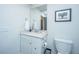 A well-lit bathroom features a vanity with quartz countertop and a framed mirror with a stylish toilet at 1641 Florentia St, Mount Pleasant, SC 29464