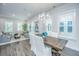 Bright dining room boasts natural light, elegant chandelier, and rustic wood table with seating for six at 1641 Florentia St, Mount Pleasant, SC 29464