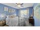 Comfortable bedroom with a ceiling fan, light blue walls, and a window with patterned curtains at 1738 Towne St, Johns Island, SC 29455