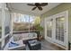 Cozy screened-in porch with comfortable seating, ceiling fan, and a view of the fenced backyard at 1738 Towne St, Johns Island, SC 29455