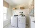 Bright laundry room featuring a modern washer and dryer, storage shelf, and stylish decor at 203 Pine Crest View Dr, Summerville, SC 29486