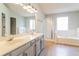 Relaxing bathroom featuring double sinks, a glass shower, and a large soaking tub at 204 Candleberry Cir, Goose Creek, SC 29445