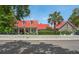 Charming home with a red roof, dormer windows, white picket fence, and manicured landscaping at 204 Live Oak Dr, Mount Pleasant, SC 29464