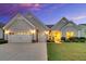 Charming one-story home featuring a manicured lawn, a two-car garage and a welcoming front porch at 205 Potters Pass Dr, Summerville, SC 29486