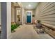 Cozy covered front porch with a blue door, comfortable seating and a decorative brick accent wall at 205 Potters Pass Dr, Summerville, SC 29486