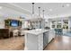 An open kitchen and living area featuring white cabinets, a large island, stainless steel appliances, and hardwood floors at 205 Potters Pass Dr, Summerville, SC 29486