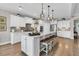 Bright kitchen with white cabinets, stainless appliances, large island with barstool seating, and hardwood floors at 205 Potters Pass Dr, Summerville, SC 29486