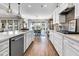 An open kitchen and dining area features white cabinetry, a large island, stainless steel appliances, and a view to the backyard at 205 Potters Pass Dr, Summerville, SC 29486