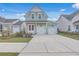Charming two-story home featuring a pink front door, light green siding, and two-car garage at 219 Clearblue Loop, Summerville, SC 29486