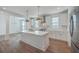 Bright kitchen featuring stainless steel appliances, a large island with pendant lighting and wooden floors at 219 Clearblue Loop, Summerville, SC 29486