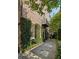 Exterior elevation of a brick home with lush vines, a small balcony, and a stone pathway at 23 Elliott St, Charleston, SC 29401