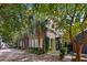 Beautiful brick home with lush greenery, palm trees, and sidewalk access on a sunny day at 23 Elliott St, Charleston, SC 29401