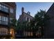 Exterior view of the residence showcasing brick facade, palm trees, and inviting architectural details at dusk at 23 Elliott St, Charleston, SC 29401