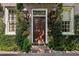 Charming front door adorned with classic lanterns and surrounded by lush greenery at 23 Elliott St, Charleston, SC 29401