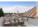 Balcony view showcasing a steeple and the surrounding cityscape, framed by lush greenery and seating at 23 Elliott St, Charleston, SC 29401