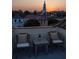 Charming rooftop with chairs, wine, and stunning city views at sunset at 23 Elliott St, Charleston, SC 29401
