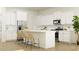 Modern kitchen with stainless steel appliances, white cabinetry, an island with bar seating, and tile backsplash at 233 Denham St, Summerville, SC 29486
