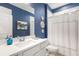 Bathroom featuring blue accent wall, white vanity with chrome fixtures, and shower/tub combo with decorative shower curtain at 236 River Martin Ct, Summerville, SC 29483