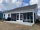 Exterior view of the back of the home, including a screened in porch, outdoor grill, and patio at 236 River Martin Ct, Summerville, SC 29483