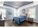 Bright bedroom features blue accent ceiling, hardwood floors, and a neutral toned decorative sunburst mirror at 236 River Martin Ct, Summerville, SC 29483