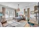 Stylish bedroom featuring a wood bed frame, brown leather sofa, desk and large windows at 25 Duany Rd, Mount Pleasant, SC 29464