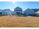 Expansive backyard featuring a well-maintained lawn, screened porch, and a stamped concrete patio with dining area at 2613 Hatch Dr, Johns Island, SC 29455