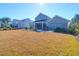 Expansive backyard featuring a well-maintained lawn, screened porch, and a stamped concrete patio with dining area at 2613 Hatch Dr, Johns Island, SC 29455