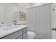 Well-lit bathroom features a modern vanity, toilet, and shower with a stylish patterned curtain at 2613 Hatch Dr, Johns Island, SC 29455