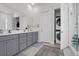Modern bathroom features double vanity, gray cabinets, and a convenient stacked washer and dryer at 2613 Hatch Dr, Johns Island, SC 29455