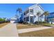 Attractive two-story home boasting a detached garage, and manicured lawn with palm trees at 2613 Hatch Dr, Johns Island, SC 29455