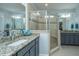 Bathroom featuring dual sinks, granite counters, and a tiled shower with glass surround at 3034 Cross Vine Ln, Summerville, SC 29483