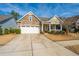 Inviting home with a stone facade, a two-car garage, and a quaint front porch at 3034 Cross Vine Ln, Summerville, SC 29483