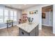 Bright kitchen featuring an island with granite countertop, wood-look tile floor, and large windows at 3034 Cross Vine Ln, Summerville, SC 29483