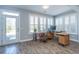 Home office space with lots of natural light, wood-look tile floors, and modern desk setup at 3034 Cross Vine Ln, Summerville, SC 29483