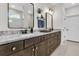 This bathroom offers dual sinks, marble countertops, dark wood cabinets, and a separate area for the shower at 306 Autumn Azalea Way, Summerville, SC 29486