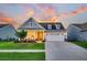 Charming home with a manicured lawn, inviting front porch, and a two-car garage at sunset at 306 Autumn Azalea Way, Summerville, SC 29486