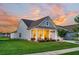 Charming single-Gathering home with a manicured lawn, inviting front porch, and colorful sunset at 306 Autumn Azalea Way, Summerville, SC 29486