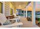Cozy front porch featuring two white Adirondack chairs with decorative pillows and flowers, at sunset at 306 Autumn Azalea Way, Summerville, SC 29486