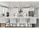 A gourmet kitchen boasts a large island with seating, quartz countertops, stainless steel appliances, and pendant lights at 306 Autumn Azalea Way, Summerville, SC 29486