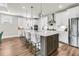 A modern kitchen features a large island with quartz countertops, stainless steel appliances, and pendant lighting at 306 Autumn Azalea Way, Summerville, SC 29486
