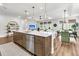 A modern kitchen with a large island, stainless steel appliances, and an open concept to the dining and living area at 306 Autumn Azalea Way, Summerville, SC 29486