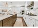 A bright, modern kitchen with stainless steel appliances, white cabinets, large island, and hardwood flooring at 306 Autumn Azalea Way, Summerville, SC 29486