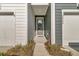 Inviting front entrance with blue siding, a gray front door and a view of the garage doors to the left at 3066 Emma Ln, Mount Pleasant, SC 29466
