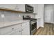 This contemporary kitchen has stainless steel appliances, stylish gray backsplash tiles, and white cabinets at 3066 Emma Ln, Mount Pleasant, SC 29466