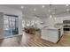 Open-concept living room with wood floors, leading to the kitchen and featuring a sliding glass door to the patio at 3066 Emma Ln, Mount Pleasant, SC 29466
