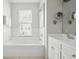 Bright bathroom featuring soaking tub, travertine tile floors, large mirror and modern fixtures at 33 Calhoun St # 218, Charleston, SC 29401